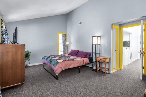 a spacious bedroom with a bed and a cabinets