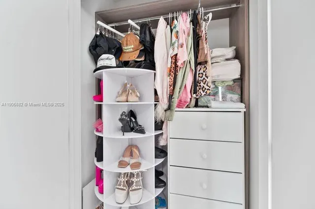 a view of walk in closet with clothes and shoes