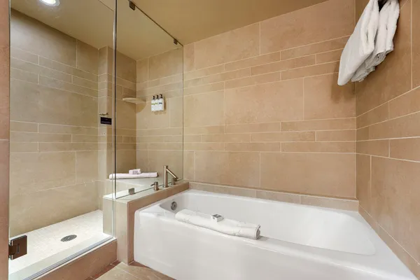 a bathroom with a tub a toilet and a shower