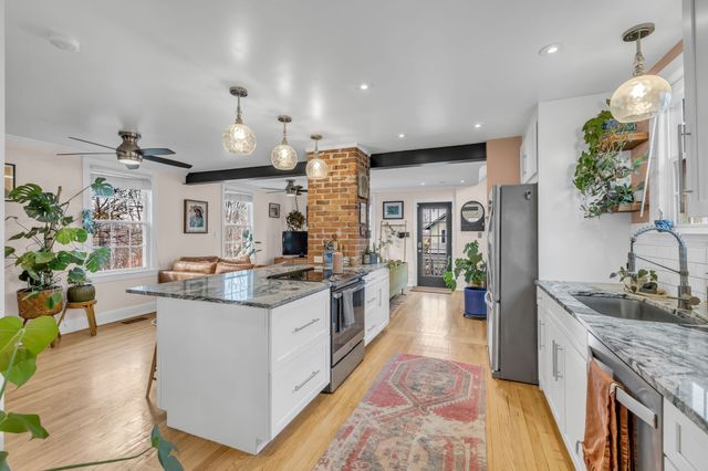 a living room with furniture a flat screen tv and a window
