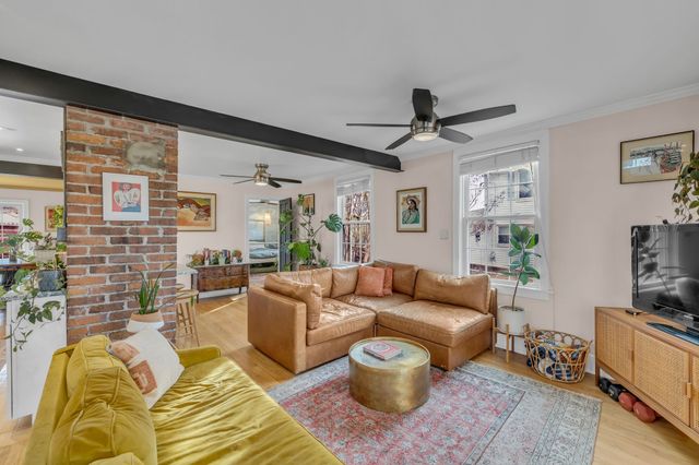 a kitchen with stainless steel appliances white cabinets and wooden floor