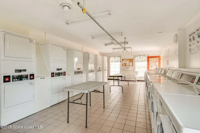 a kitchen with granite countertop lots of white cabinets and chandelier