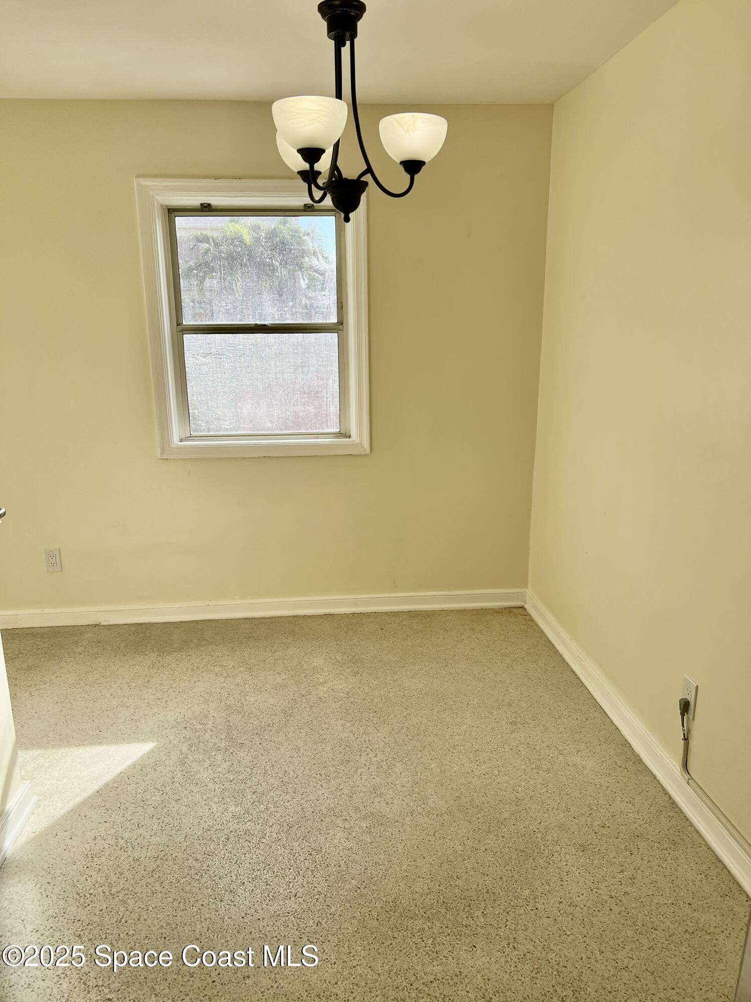 931 Palm Springs Boulevard, Unit B Indian Harbour Beach, FL 32937 - Photo 4 of 16 a view of a room with a wooden floor and a window
