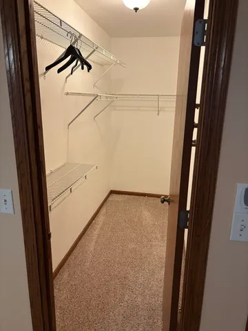 an empty room with closet and chandelier fan