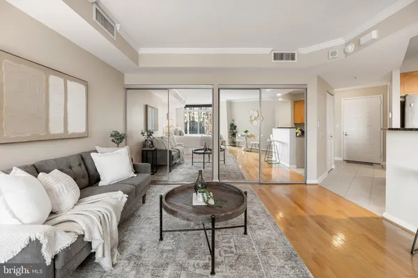 a living room with furniture a rug kitchen view and a large window