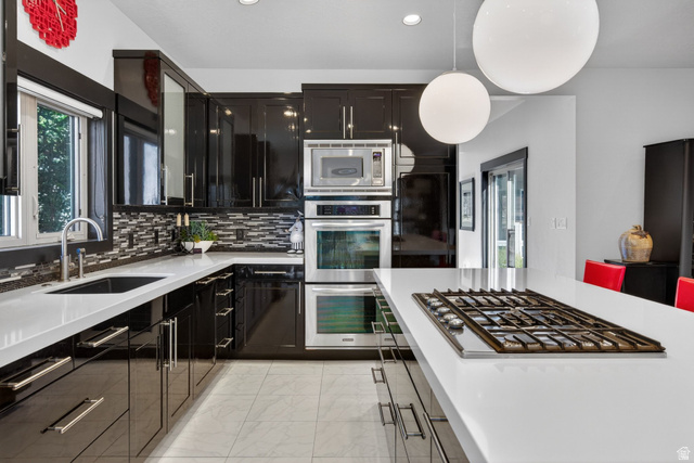 145 Carnesecca Court Mapleton, UT 84664 - Photo 26 of 109 Kitchen with stainless steel appliances, light marble finish floors, light stone countertops, decorative backsplash, and hanging light fixtures