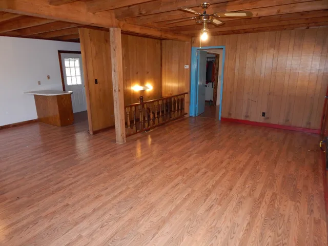 a view of room with wooden floor and furniture