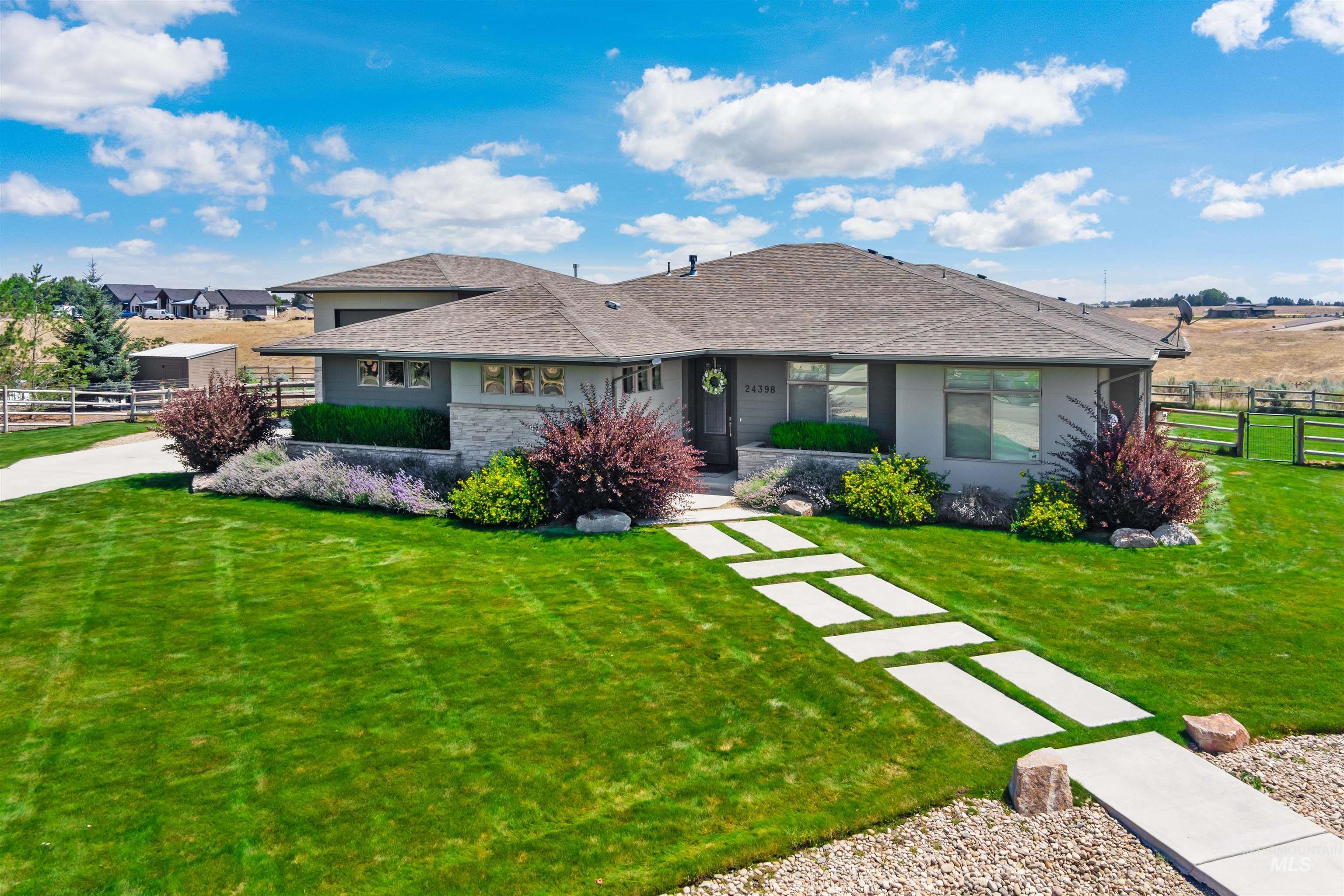 24398 Tombstone Ridge Court Middleton, ID 83644 - Photo 35 of 47 Modern ranch-style residence featuring a stucco and stone facade, a multi-gabled roofline, and a concrete paver walkway