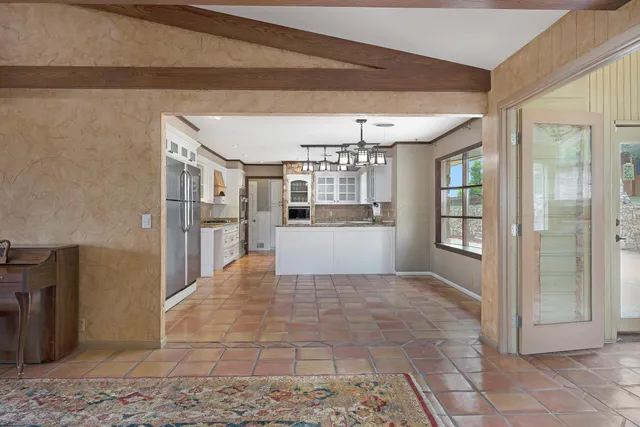 a view of a hallway with a dining table and chairs