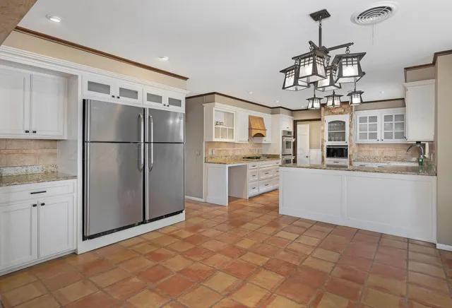 a kitchen with stainless steel appliances granite countertop a refrigerator and a sink