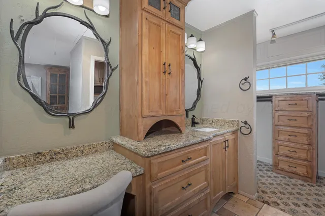 a bathroom with a granite countertop sink and a mirror
