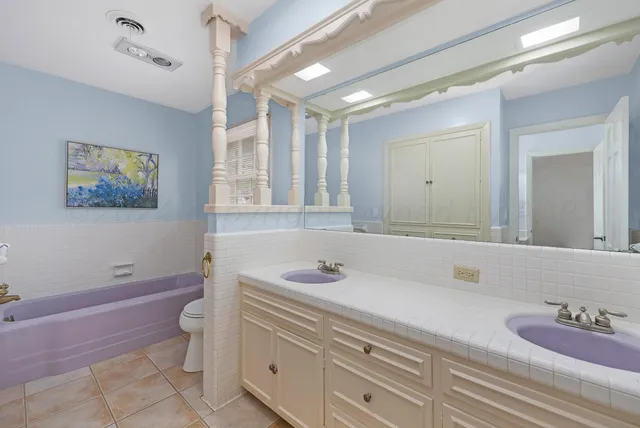 a bathroom with a granite countertop sink a toilet and a bathtub