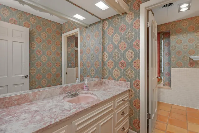 a bathroom with a granite countertop sink and a mirror