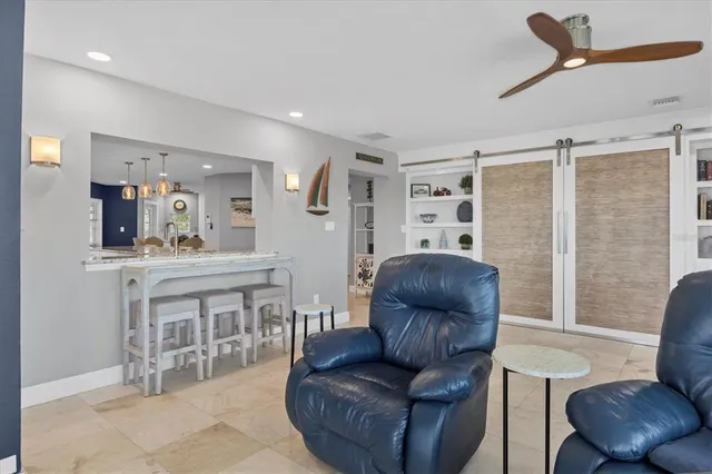 a kitchen with stainless steel appliances kitchen island granite countertop a sink a stove a refrigerator cabinets and chairs