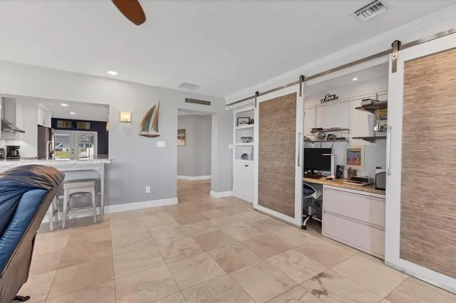 a kitchen with stainless steel appliances kitchen island granite countertop a refrigerator a stove a microwave oven a sink with a dining table and chairs