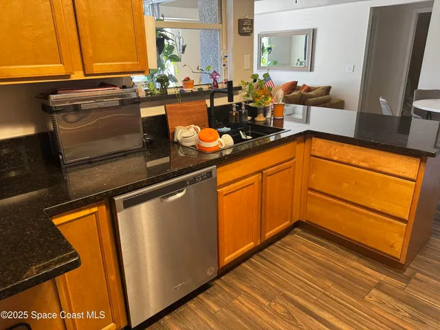 a kitchen with granite countertop wooden cabinets and a sink
