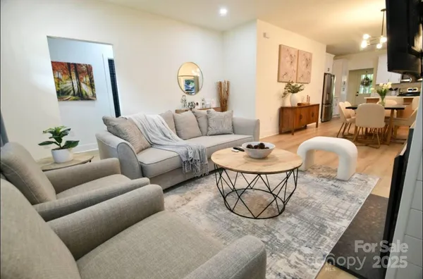 a living room with furniture a rug and a table