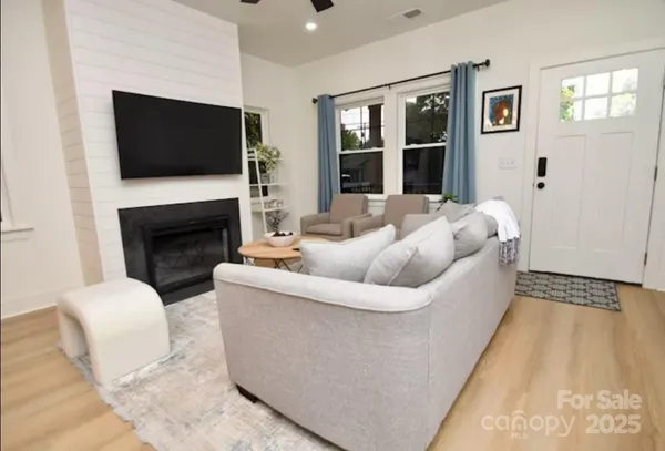 a living room with furniture a flat screen tv and a fireplace