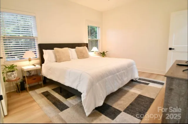 a bedroom with a bed and wooden floor