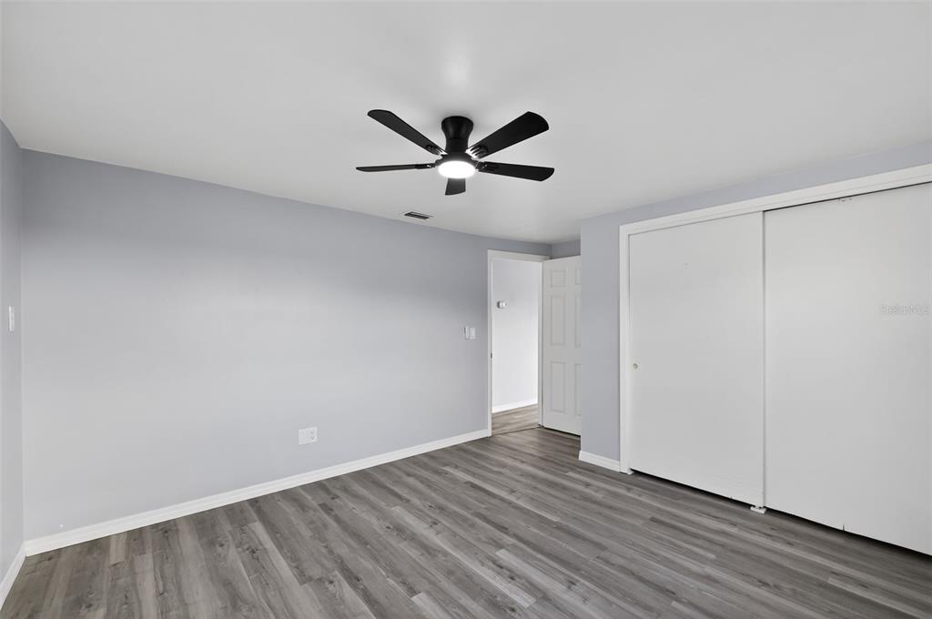 4086 Arrowhead Avenue Spring Hill, FL 34606 - Photo 11 of 21 an empty room with wooden floor and ceiling fan
