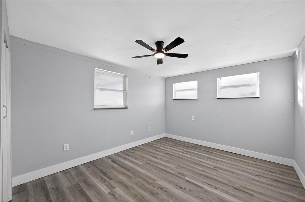 4086 Arrowhead Avenue Spring Hill, FL 34606 - Photo 14 of 21 a view of a room with wooden floor and a ceiling fan