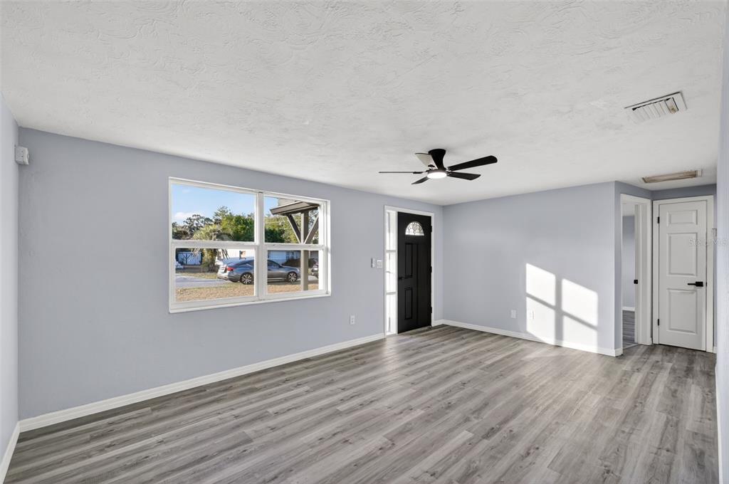 4086 Arrowhead Avenue Spring Hill, FL 34606 - Photo 5 of 21 a view of an empty room with a window and wooden floor
