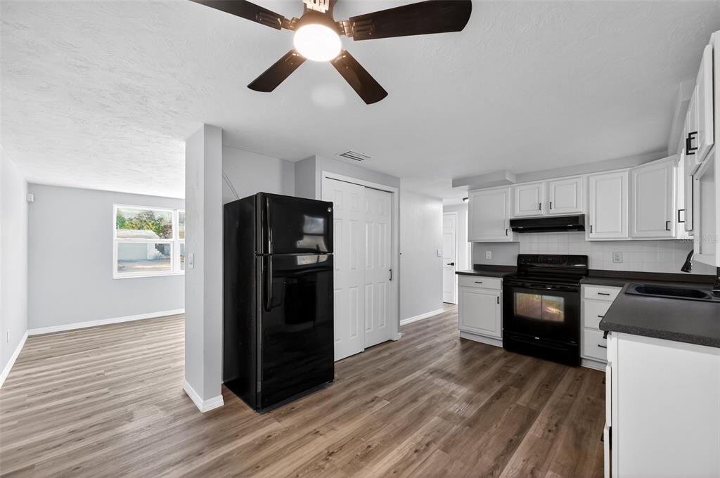 4086 Arrowhead Avenue Spring Hill, FL 34606 - Photo 7 of 21 a kitchen with granite countertop stainless steel appliances a refrigerator cabinets and wooden floor