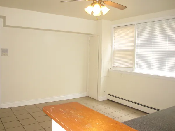 an empty room with a chandelier fan