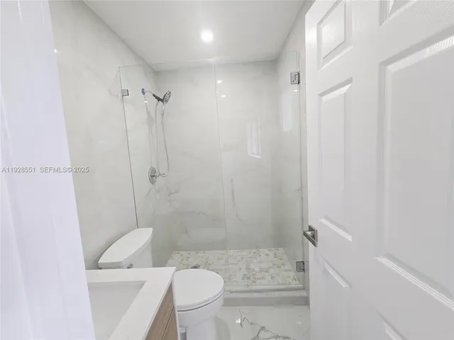 a bathroom with a shower a toilet and sink