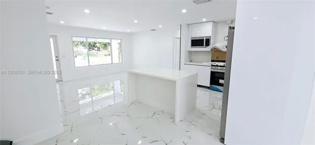 a view of kitchen with windows and refrigerator