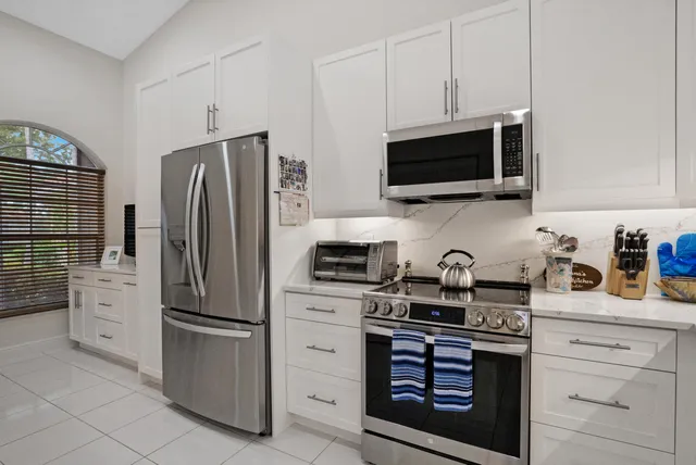 a kitchen with stainless steel appliances granite countertop a refrigerator stove and microwave