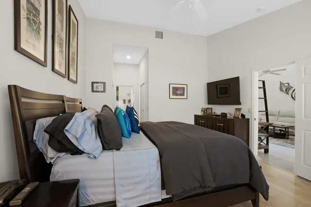 a bed room with a bed a television and dresser