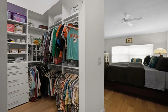 a view of walk in closet with clothes and shoes