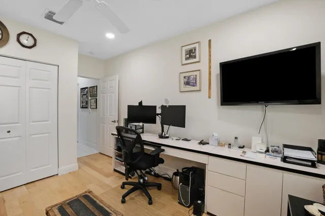 a view of a workspace with a flat screen tv and a window