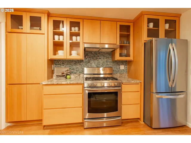 a kitchen with stainless steel appliances granite countertop a refrigerator and a stove top oven