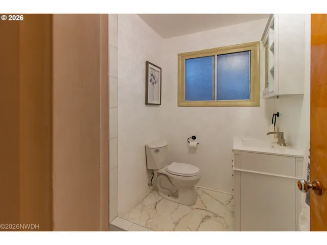 a bathroom with a toilet a sink and mirror