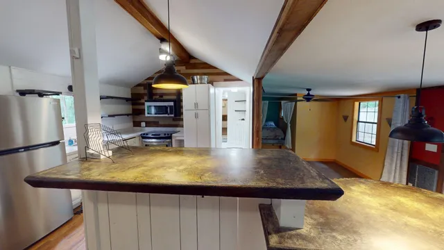 a view of a kitchen with appliances and furniture