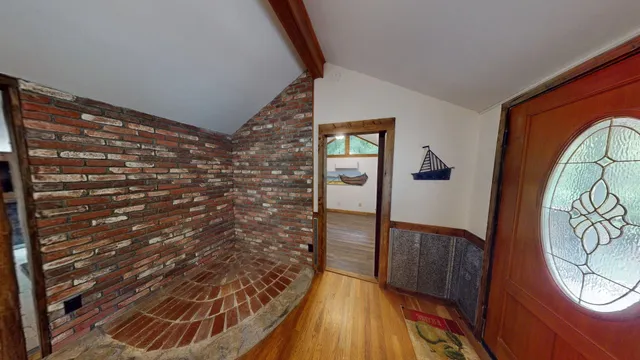 a view of a kitchen with fridge and wooden floor