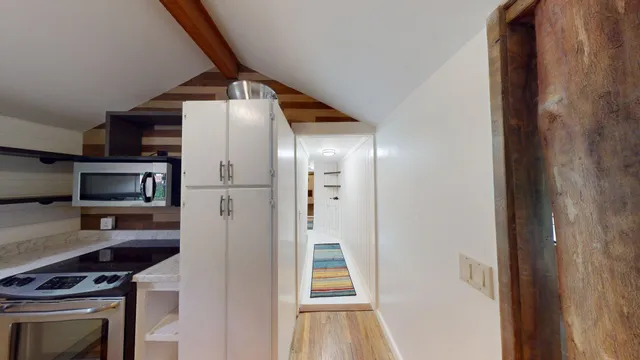 a view of a hallway with wooden floor and staircase