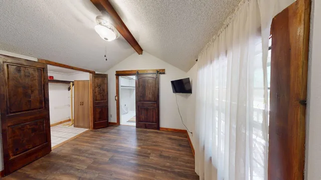 a view of a hallway with wooden floor and staircase