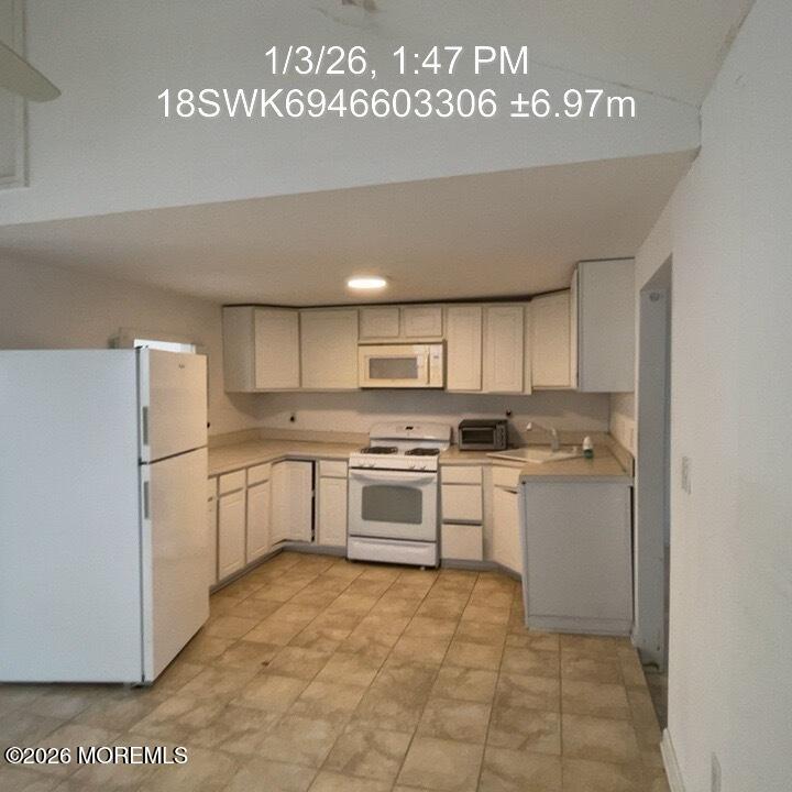 115 Bonita Road Waretown, NJ 08758 - Photo 16 of 18 a kitchen with a refrigerator and white cabinets