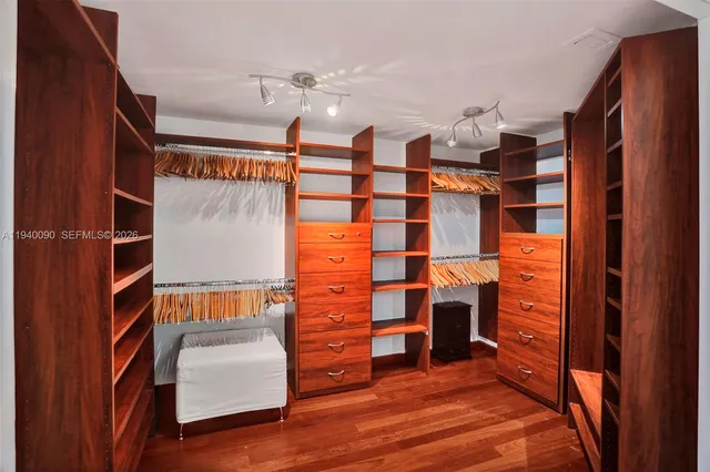 a view of walk in closet with clothes and shoes