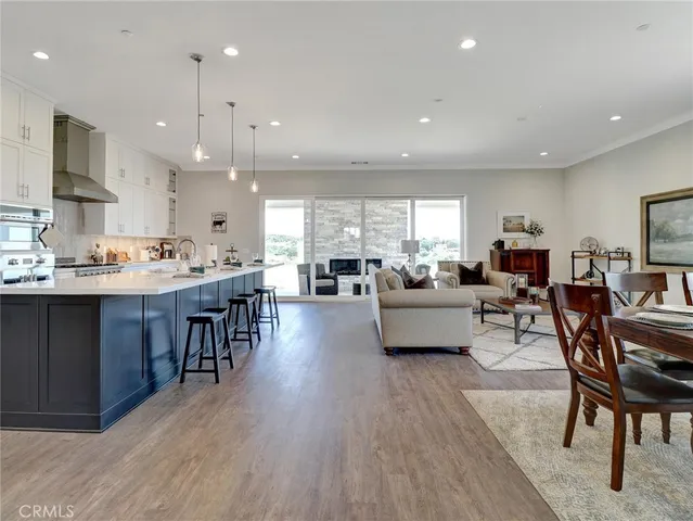 a living room with stainless steel appliances kitchen island granite countertop furniture wooden floor and a view of kitchen