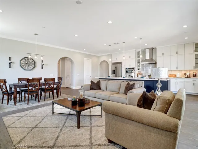 a living room with lots of furniture and view of kitchen