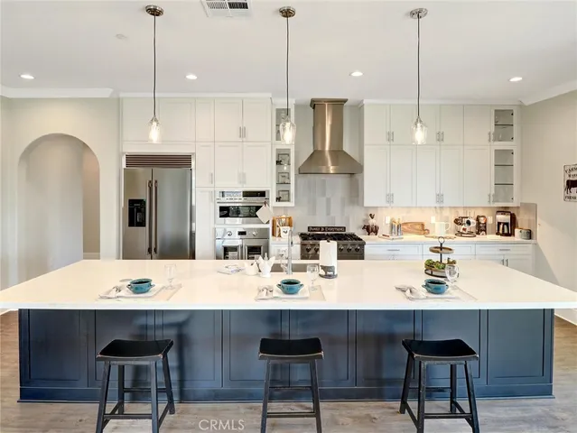 a kitchen with kitchen island stainless steel appliances a table chairs refrigerator sink and microwave