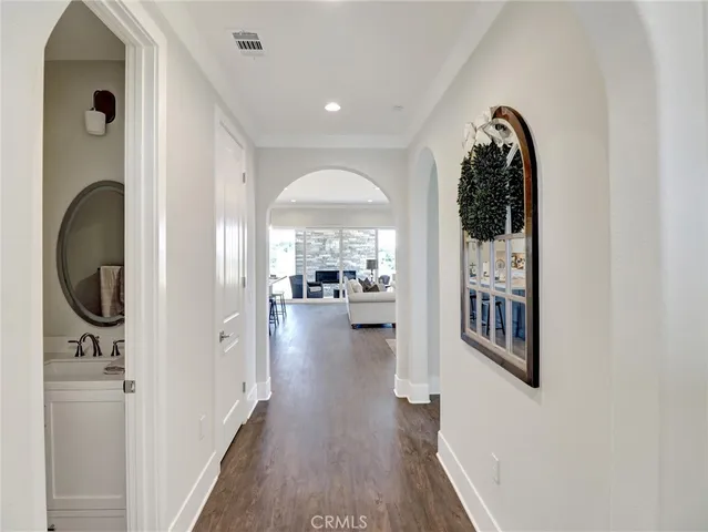 a view of a hallway with wooden floor and dining room
