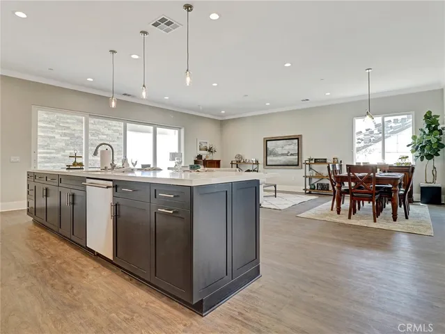 a kitchen with stainless steel appliances a refrigerator a stove a sink and white cabinets