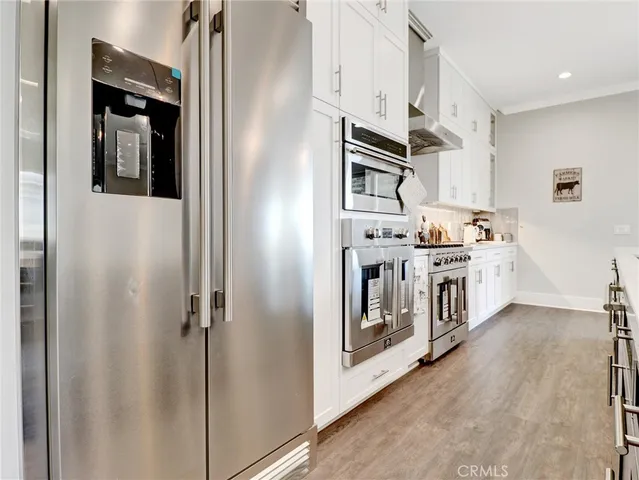 a kitchen with stainless steel appliances granite countertop a sink a stove and a wooden floors