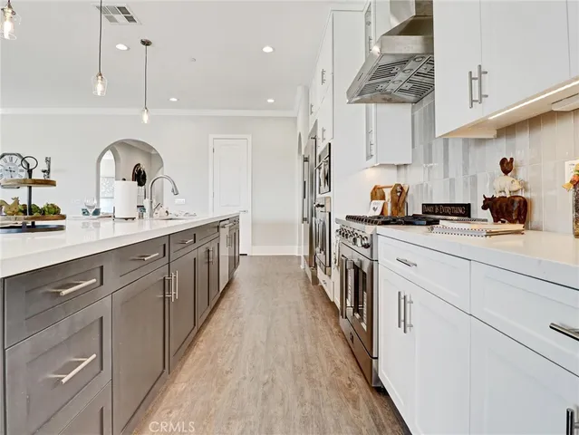 a kitchen with stainless steel appliances white cabinets and a refrigerator