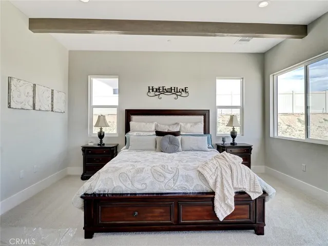 a bedroom with a bed and large windows